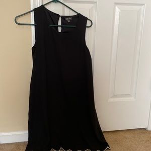 Sleeveless black dress, white stitching on bottom